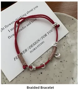 Close-up of red braided rope bracelet with S925 silver charms and beige thread detail
