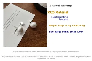 Macro detail of S925 sterling silver ball earrings featuring brushed matte texture finish