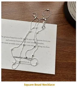 Detail of S925 sterling silver chain featuring minimalist square beads on a textured card