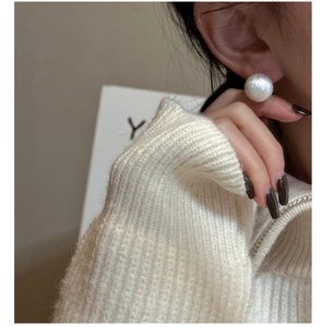 Close-up of S925 sterling silver brushed round stud earrings worn on a model's ear