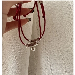 Dettaglio della sfera in argento S925 su bracciale in corda rossa intrecciata