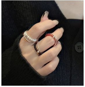 Close-up of stacked S925 silver rings with pearl white and reddish brown beads