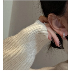Close-up of textured S925 sterling silver hoop earring worn on a female model