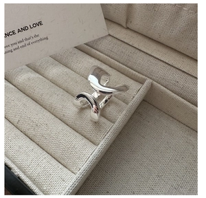 Detailed view of polished S925 sterling silver double layered wave ring in beige box