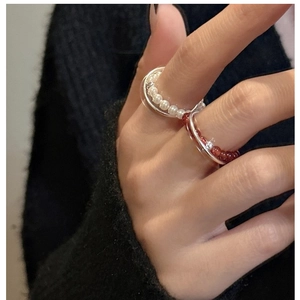 Detailed view of layered S925 sterling silver rings with pearl and red agate beads