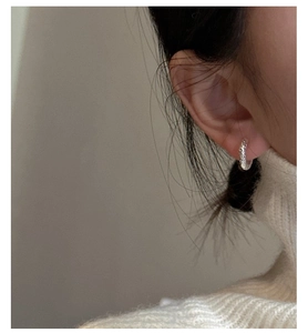 Close-up of S925 sterling silver hoop earrings featuring irregular hammered texture design