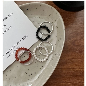 Close-up of a 6-piece silver ring set with beads on a ceramic tray for a modern look
