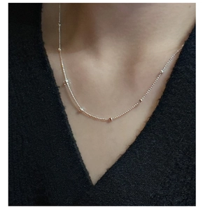 Close-up of minimalist S925 sterling silver beaded chain necklace on a model