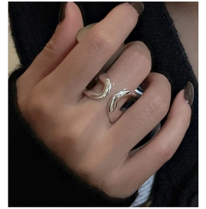Detail of minimalist double-layered silver ring with irregular streamlined wide surface