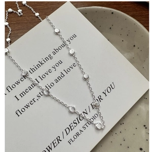 Detail of S925 sterling silver chain with textured beads on a minimalist white card