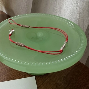 Bracelet en argent S925 avec cordon rouge et pendentifs poisson sur plateau déco
