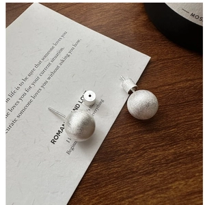 Detailed macro view of S925 sterling silver ball stud earrings with matte brushed finish