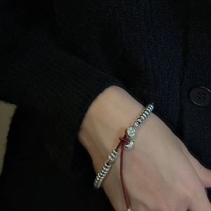 Bracelet minimaliste en argent sterling S925 avec fil rouge et perles porté au poignet