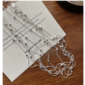 Close-up of S925 sterling silver beaded chain necklace with polished cube accents