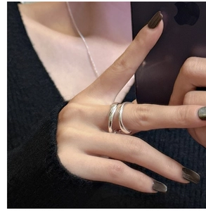 Macro shot of minimalist silver double-layer wave ring worn by a model in ins style