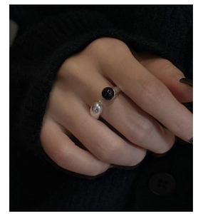 Close-up of a minimalist S925 silver ring featuring a black agate bead on a knit sweater