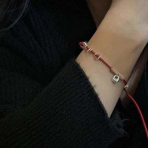 S925 silver red string bracelet with sycee charm and bells on a model's wrist