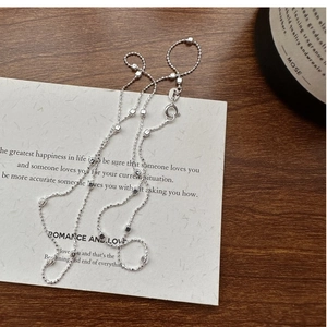 Detailed macro view of S925 sterling silver beaded chain with spring clasp on white card