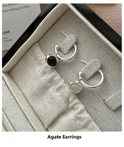 Close-up of S925 silver earrings featuring black and white agate stone pendants