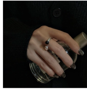 Detail of adjustable S925 silver ring featuring black agate bead and silver ball charm
