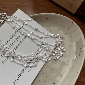 Italian S925 sterling silver necklace with textured disk pendants on a ceramic tray