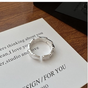 Macro shot of silver ring with hammered texture detail and adjustable open band design