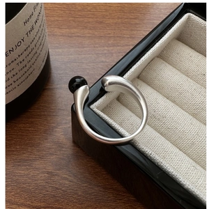 Close-up of S925 sterling silver open ring with polished black onyx bead on a jewelry box