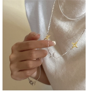 Gros plan du collier étoilé multicouche en argent 925 avec contraste bicolore