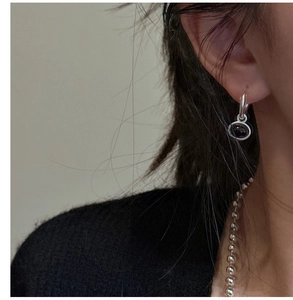 Detail view of silver drop earrings with black agate and a minimalist ball chain necklace