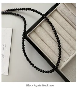 Close-up of black agate beaded necklace on a premium velvet jewelry display box