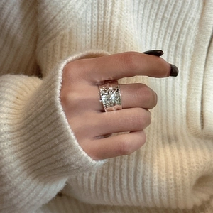S925 sterling silver wide ring with hammered texture worn on a knit background