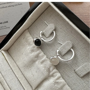 Macro shot of S925 silver matte hoop earrings with black and white teardrop charms