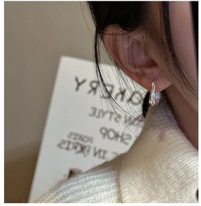 Gros plan sur des boucles d'oreilles gouttes en argent S925 portées par un mannequin
