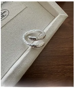 Detailed view of the S925 sterling silver stamp on the textured crossover ring