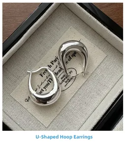Macro shot of silver U-shaped earrings in a jewelry box with S925 hallmark detail