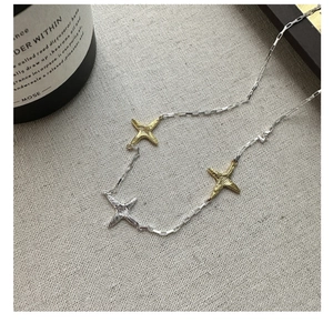Détail macro du collier en argent 925 avec pendentifs étoiles texturés or et argent