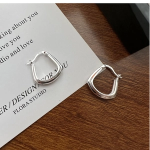 Vue détaillée montrant le poinçon S925 sur les boucles d'oreilles créoles carrées en argent