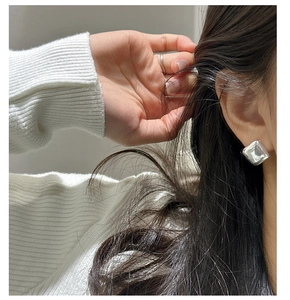 Close-up of minimalist S925 sterling silver square hoop earrings on a model ear