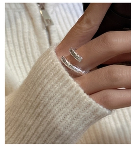 Detailed view of S925 sterling silver crossover ring with hammered texture on a finger