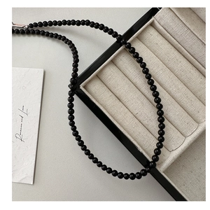 Detail of black agate beaded necklace with silver lobster clasp on a jewelry box