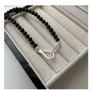 Close-up of black agate beaded necklace with S925 silver clasp and hallmark engraving