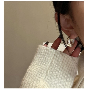 Close-up of chunky S925 sterling silver U-shaped hoop earring on model ear lobe