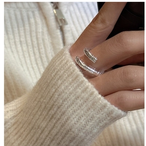 Close-up of S925 sterling silver crossover ring with hammered texture on a hand