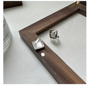 Macro view of minimalist square S925 sterling silver hoop earrings with a mirror finish