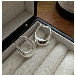 Detailed close-up of S925 sterling silver stamp on minimalist U-shaped hoop earrings