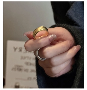 Makroansicht gestapelter minimalistischer dicker Silber und Gold Ringe an den Fingern
