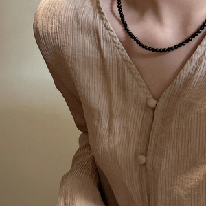 S925 sterling silver black agate beaded choker worn with a pleated V-neck shirt