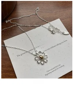 Close-up of S925 sterling silver daisy necklace with gold core and hallmark stamp