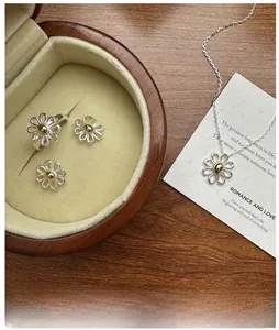 Detail of silver daisy jewelry set with gold centers on a velvet jewelry box