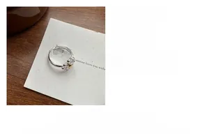Close-up of S925 sterling silver daisy ring with yellow core and white enamel petals